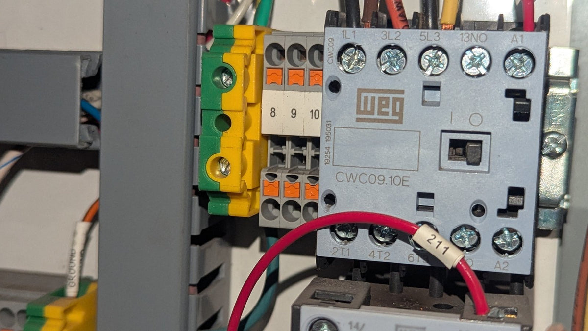 Close-up of a contactor nameplate in a control panel showing the model number CWC09.10E
